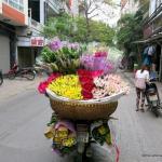 A motobike with a giant basket of flowers on the back in Hanoi.