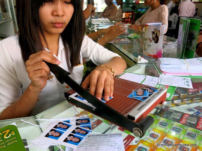 Girl cutting passport photos at Good Luck Printing Phnom Penh